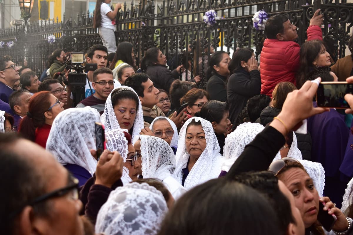 Sahumadoras con mantillas blancas entre los fieles que esperan el paso de la procesión